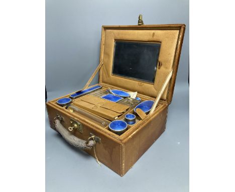 A late 19th/early 20th century French ten piece white metal and blue guilloche enamel travelling toilet set in leather case w