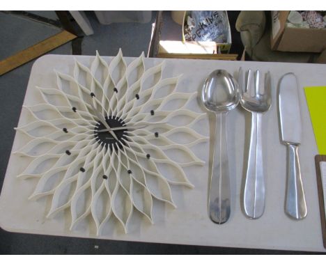 A large Karrisson wall clock together with three alloy wall hangings of a knife, fork and spoon 