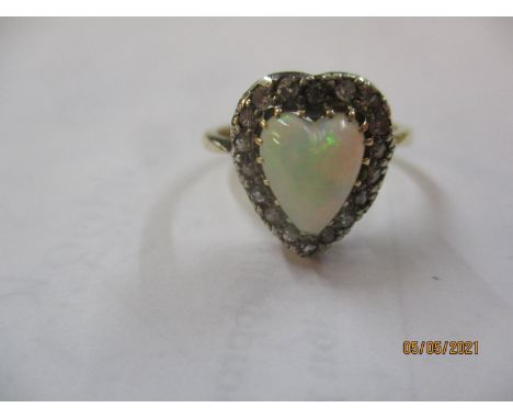 An 18ct gold band ring with silver claw having a heart shaped opal stone surrounded by moissanite chips 