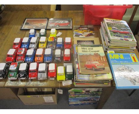 A collection of diecast model Mini cars, along with two car owners' manuals, various car magazines and two framed pictures of
