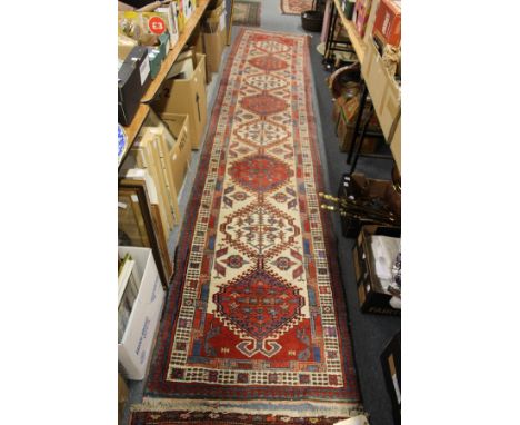 A good Persian runner / hall carpet, beige ground with eight large medallions.