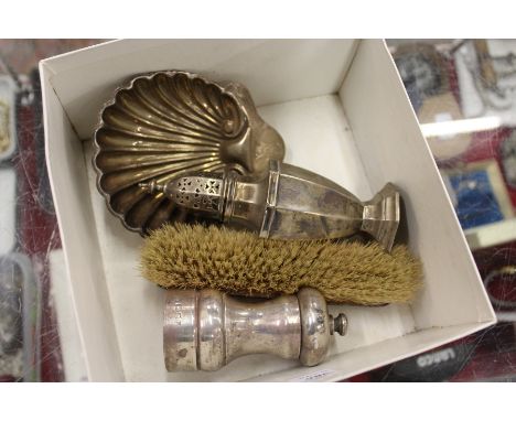 A silver pedestal sugar caster, a shell shaped butter dish, a pepper grinder and hand brush.