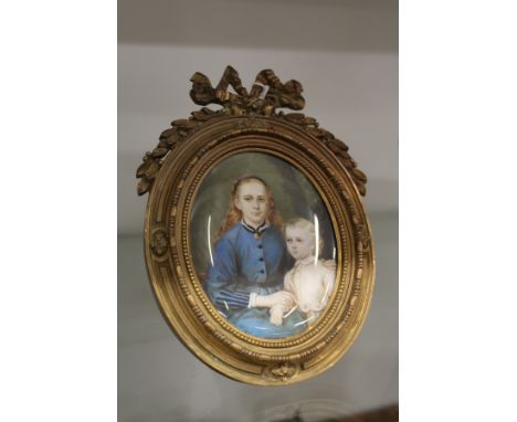 A good 19th century French oval portrait miniature of a mother and child in an ormolu easel frame.