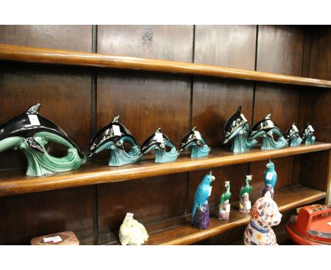 Two sets of Poole pottery dolphin families.