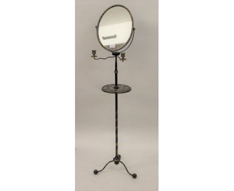 19th Century black japanned gilded metal and papier mache shaving stand, the oval swing frame mirror above a pair of candle h