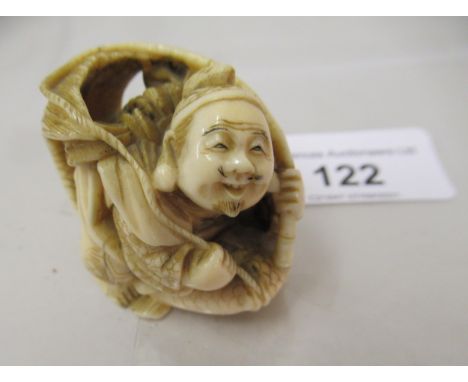 Japanese Meiji period carved ivory netsuke in the form of a seated fisherman with nets, signed with red seal mark to base 