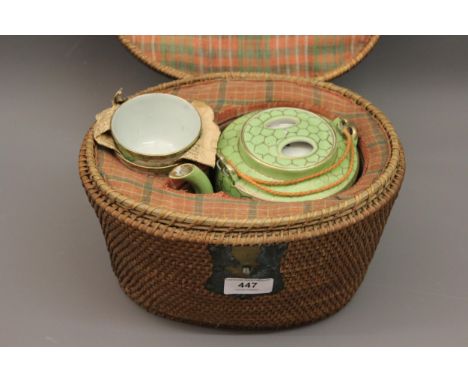 Chinese porcelain teapot with two tea bowls, in original fitted basket 