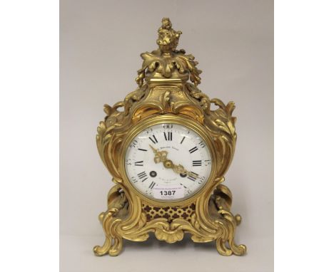 19th Century French ormolu mantel clock of rococo design, the enamel dial with Arabic and Roman numerals, signed E. Domange-R