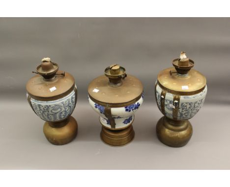 Three blue and white porcelain brass mounted oil lamp burners (lacking shades), 14.5ins and 16ins high each 