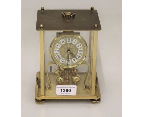 Modern brass three hundred day clock in a four glass case together with a modern mantel clock with quartz movement 