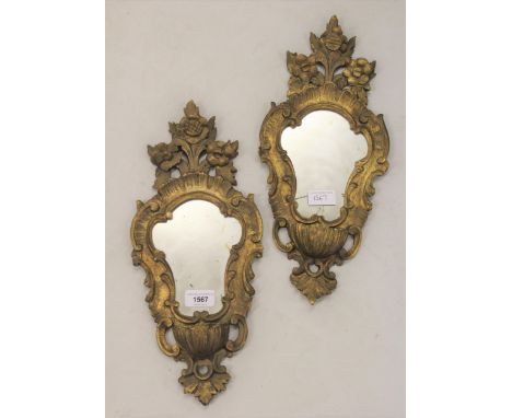 Pair of Italian carved giltwood wall mirrors with floral decoration, 16ins high and a cream painted and gilded table lamp bas
