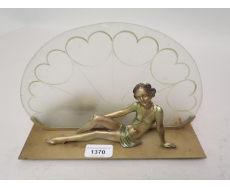 Art Deco painted metal table lamp in the form of a seated girl before an opaque glass fan shaped shade, 10ins wide 