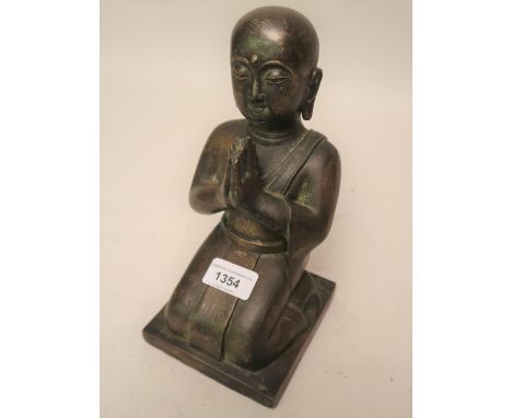 Antique patinated bronze figure of kneeling Buddha with traces of gilt and vertdegris, 9ins high 