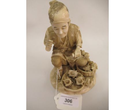 Japanese Meiji period carved ivory figure of a crouching man with baskets of shells, signed to the underside of the naturalis