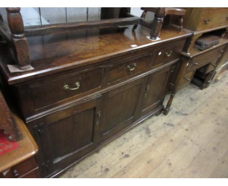 19th Century oak dresser base with three drawers above two panel doors flanking a fixed centre panel, on low bracket feet, 56