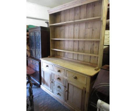 19th Century pine dresser, the boarded shelf back above an arrangement of six drawers and two moulded panel doors with knob h