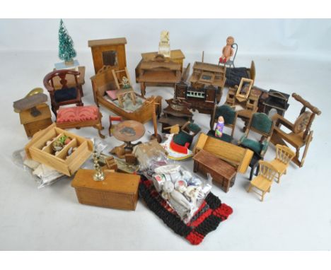 A group of late 19th/early 20th century mainly wooden dolls house furniture and furnishings including bed, dressing table, ro