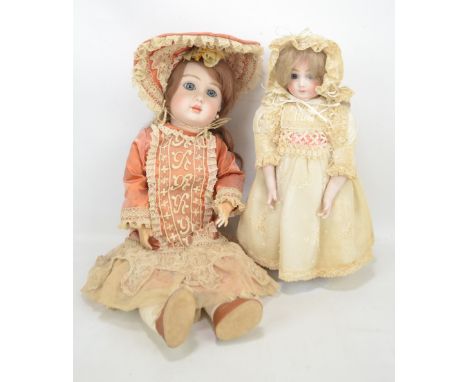 Two reproduction bisque headed Steiner dolls, both with open glass eyes, closed mouths and painted features, mohair wigs, the