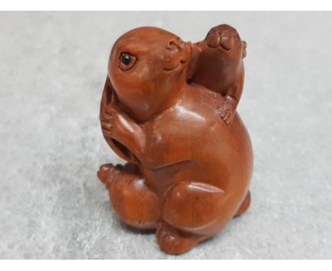 A finely carved Chinese hardwood netsuke depicting two rabbits.