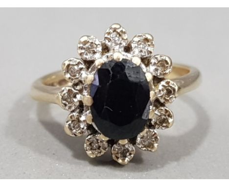 Ladies 9ct yellow gold sapphire &amp; diamond cluster ring, featuring a black sapphire set in the centre, surrounded by 12 ro