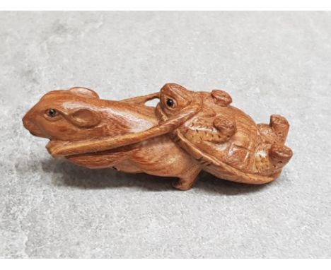 A finely carved Chinese hardwood netsuke depicting a rat towing a turtle.