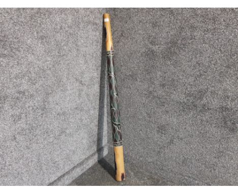 A carved wooden  didgeridoo with handpainted decoration.