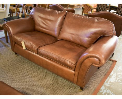 LAURA ASHLEY SOFA, with scrolling arms in a burnt sienna leather on turned supports, 205cm x 195cm x 95cm.approx.