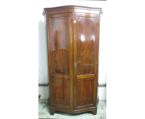 HEAL AND SON WARDROBE, Edwardian mahogany with two panelled doors enclosing a shelf over a hanging rail on bracket feet, 126c