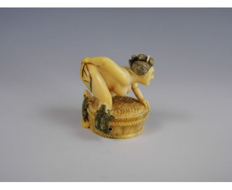 A signed late Meiji / Taisho ivory erotic netsuke modelled as a woman bathing 