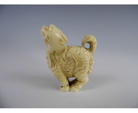 A signed Meiji Japanese netsuke or small okimono modelled as a mythical dog-like beast with scales and hoofs, 4.5 cm high