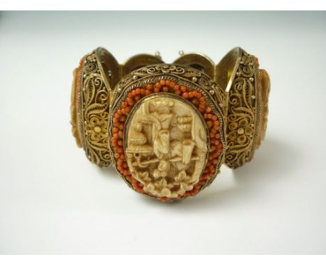 An early 20th Century silver-gilt and ivory filigree bracelet, comprising five graded oval panels, set with carved ivory plaq