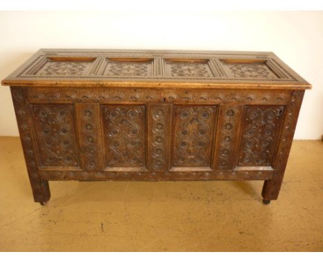 An 18th Century and later three-panel joined oak bedding chest with extensive carved decoration, 139 cm x 56 cm x 76 cm high
