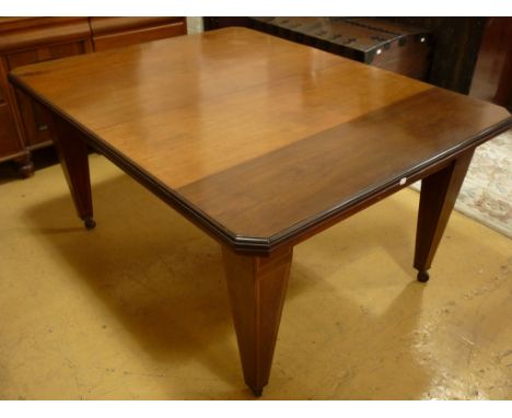 A late Victorian / Edwardian mahogany extending dining table, the oblong top having three leaves, moulded edge and canted cor