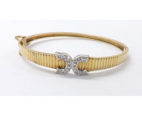 Yellow gold and diamond 'CC' bangle, set with sixteen round brilliant-cut diamonds, with safety chain, 14.9gm