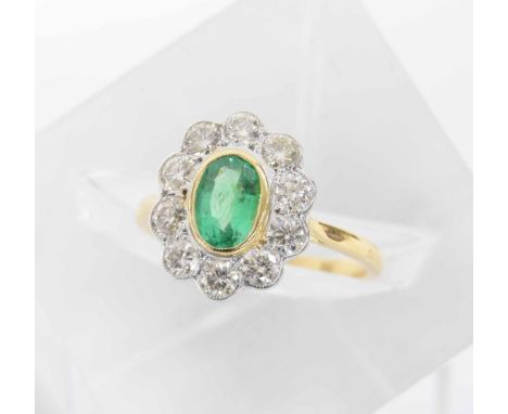 18ct oval emerald and diamond cluster ring, the emerald 0.70ct approx, round brilliant-cut diamond surround, 0.85ct approx, 1