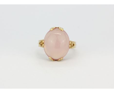 A 14ct yellow gold (stamped 14k) ring set with an oval cabochon cut rose quartz, (M.5).