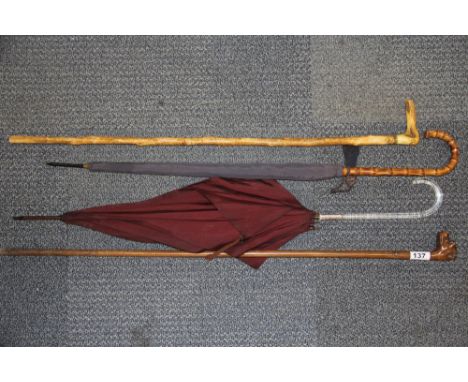 A carved wooden dogs head walking stick with single glass eye together with a further antler handle walking stick and two vin