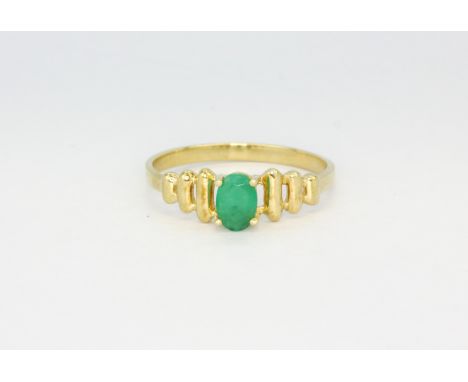 A 10ct yellow gold (stamped 10k) ring set with an oval cut emerald, (P.5).