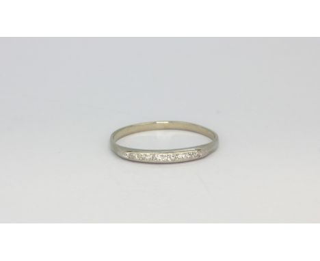 A white metal (tested 14ct gold) half eternity ring set with diamonds, (U).