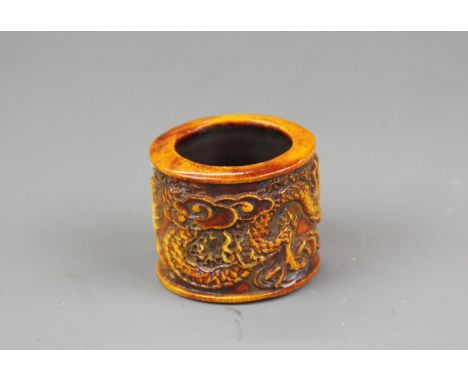 A Tibetan carved bone thumb ring decorated with a dragon, W. 2.5cm, Dia. 3cm.