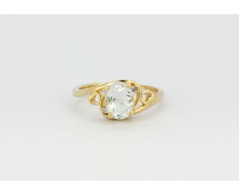 A 14ct yellow gold (stamped 14k) ring set with an oval cut aquamarine and diamonds, (N.5).