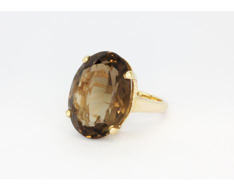 A 14ct yellow gold (stamped 14k) ring set with a large oval cut smokey quartz, (M).