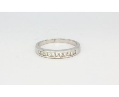 A white metal (tested minimum 9ct gold) half eternity ring set with princess cut diamonds, (L.5).