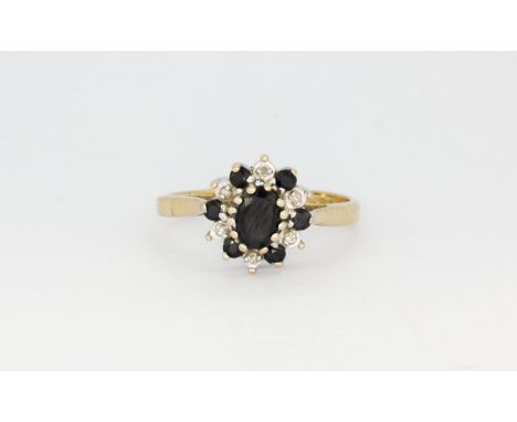 A 9ct yellow gold (stamped 9k) cluster ring set with an oval cut sapphire surrounded by diamonds and sapphires, (M.5), approx