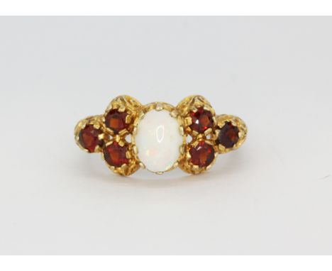 A Victorian style hallmarked 9ct yellow gold ring set with an oval cabochon cut opal and round cut garnets, (O.5), approx. 4g