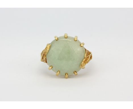 A 10ct yellow gold (stamped 10k) ring set with a large round cabochon cut jade, (M).