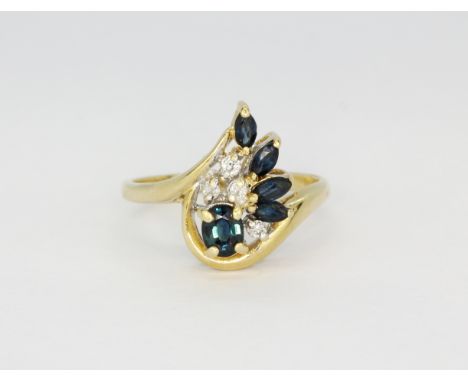 A 14ct yellow gold (stamped 14k) crossover ring set with marquise and oval cut sapphires and diamonds, (M).