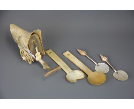 A pair of shell, white metal and mother of pearl spoons, a pair of carved horn salad servers and a carved horn bullock cart, 