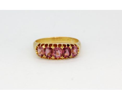 A hallmarked 18ct yellow gold ring set with cushion cut pink tourmalines, (O.5).