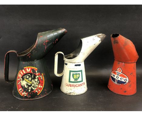A Silver Knight half gallon measure, a BP Lubricants quart measure and another for Amoco. 